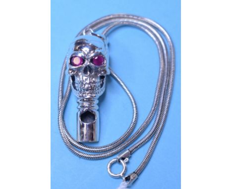 A silver whistle, in the form of a skull, with ruby eyes, on a silver chain Condition report Modern