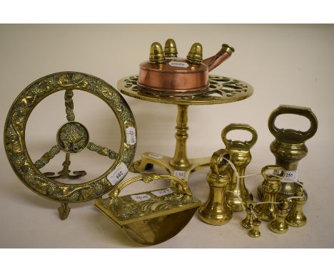A 19th century brass trivet, on a tripod platform base with paw feet, 25 cm wide, a graduated matched set of eight bell metal