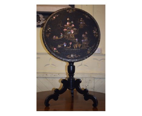 A Victorian papier-mâché tripod table, decorated dwellings and figures, 61 cm diameter