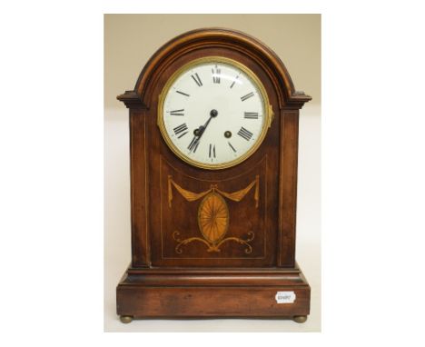 An Edwardian mantel clock, the white dial with Roman numerals, movement striking on a gong, in an inlaid mahogany fitted case