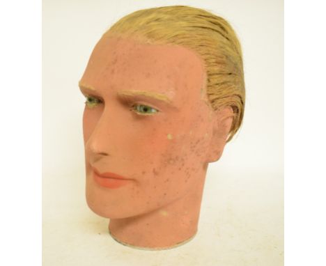 A 1930s wax male mannequin head, with glass eyes and swept backed hair, 27 cm high