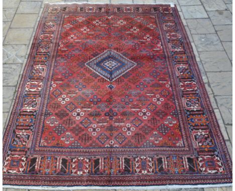 A Persian Joshagan carpet, with central medallion on a red ground, within a multi border, 358 x 264 cm