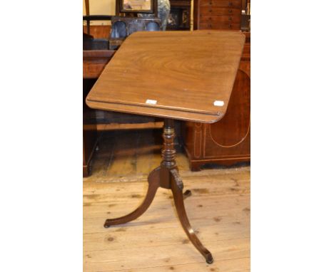 An early 19th century mahogany reading table, the adjustable top on a platform with a small drawer, a turned column and tripo