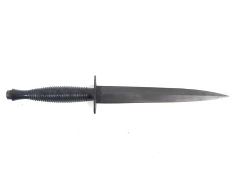 A British Commando Knife by R Cooper. The double edged blade length 17.5cm, with a brass ringed grip with a blackened finish,