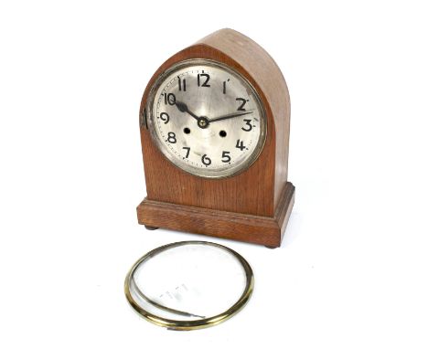 Early 20th century lancet shaped oak cased 8 day mantel clock. With a silver dial and Arabic numerals, striking to a gong. H3