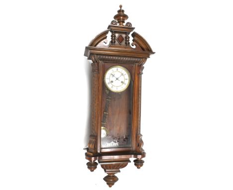 A Vienna style striking wall clock by Jungens. No. 3836. With a carved and turned wooden case. White enamel dial with Roman n