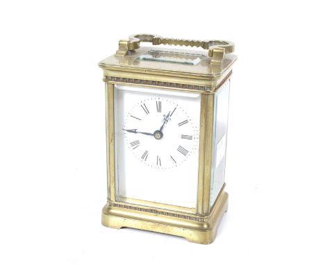 A brass carriage clock. With a white enamel dial and Roman numerals, bevel edge glass panels. H12cm