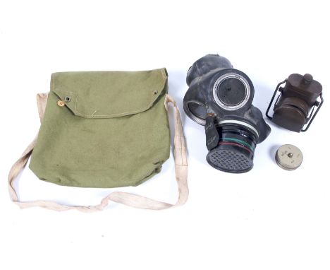 A WWII gas mask and a military electric light in a small canvas bag. The mask marked 'HT &amp;S Nov 1941', and 'Lot 5'. The p