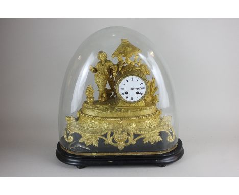 A French gilt spelter barrel cased mantel clock decorated with a standing figure of boy with foliage surround, the dial with 