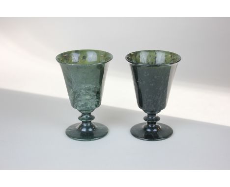 A pair of green jade wine cups, flared tapered form on knapped stems and circular bases, 10.5cm high