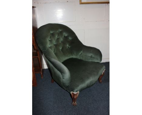 A green button upholstered armchair on carved cabriole feet