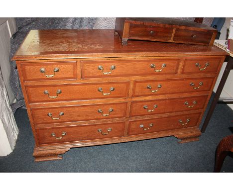 A 20th century oak chest of three short drawers over two banks of three drawers, with brass drop handles, on bracket feet, 12