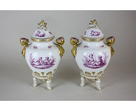 A pair of Sevres style porcelain urns and covers, depicting cherubs and Cupids in pink, the lid with overlaid flower finial, 