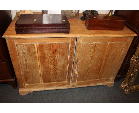 A pine rectangular cupboard with two doors enclosing shelf, on plinth base and bracket feet, 130cm