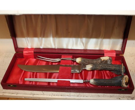 A cased carving set with horn handled silver plated fork, knife and sharpener, the blade marked Cooper Bros & Sons