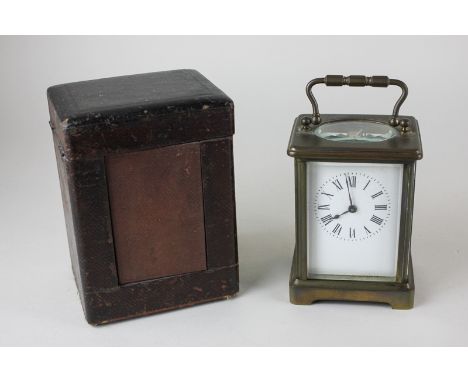 A brass and bevelled glass cased carriage clock with a leather carry case, the white enamel dial with Roman numerals, the mov