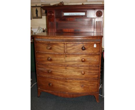 A 19th century mahogany bow front chest of two short over three graduating drawers with knob handles, carved banded frieze, o