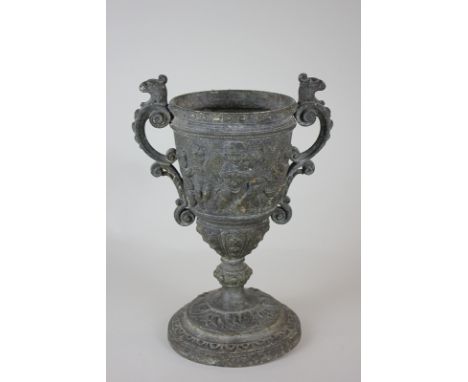 A Victorian cast iron two-handled urn embossed with a design of putti playing instruments (a/f), 26cm high