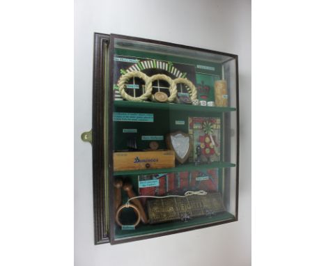 A collection of replica games memorabilia including dice, darts and cribbage, in two-tier glass display case, 57.5cm by 45cm