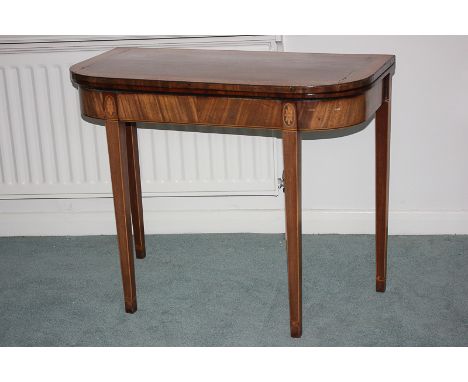 A George III mahogany card table with folding D-shaped top opening to reveal green baize with line inlaid frieze, on four squ