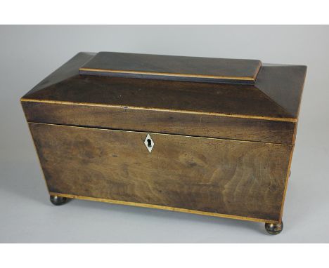 A Georgian mahogany tea caddy, sarcophagus form, with two canisters and central compartment, on brass ball feet