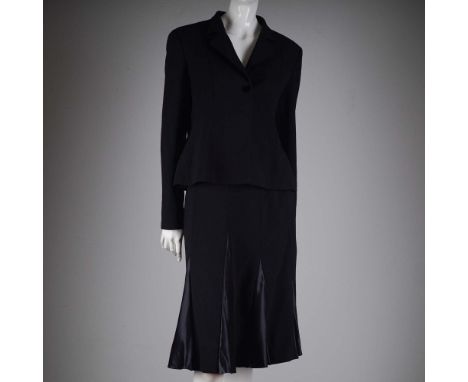 This sophisticated two-piece black skirt suit by Valentino features a tailored jacket with sharp lapels and refined detailing