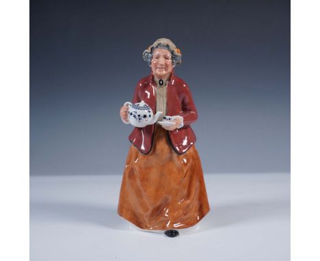 Delightful hand-painted figurine portraying an elderly woman cheerfully serving tea. She wears a deep red jacket over a cream