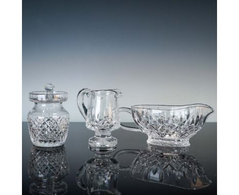 Three-piece collection of fine Waterford Crystal tableware including a footed creamer in the Lismore pattern, a sauce boat in
