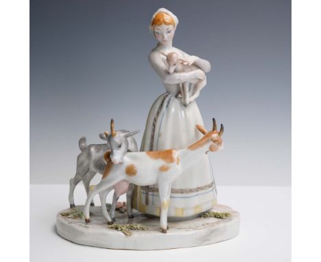 This delicate Lladro porcelain figurine depicts a shepherdess tenderly holding a fawn while two goats graze at her feet. The 