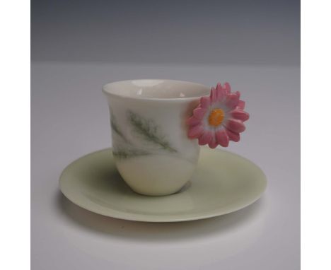 A porcelain cup and saucer set captures the beauty of nature with an elegant, soft green design accented by leaf patterns and