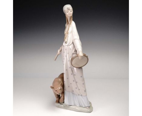 Glazed porcelain figurine of gypsy lady holding a tambourine and stick with a bear at her feet. Lladro backstamp.Artist: Salv