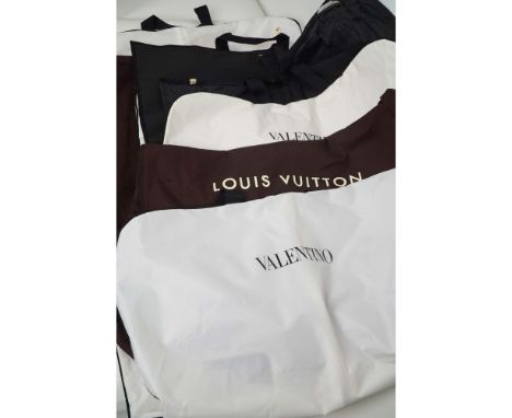 Collection of five designer garment bags from prestigious fashion houses including Louis Vuitton, Valentino, Dior, and Yves S
