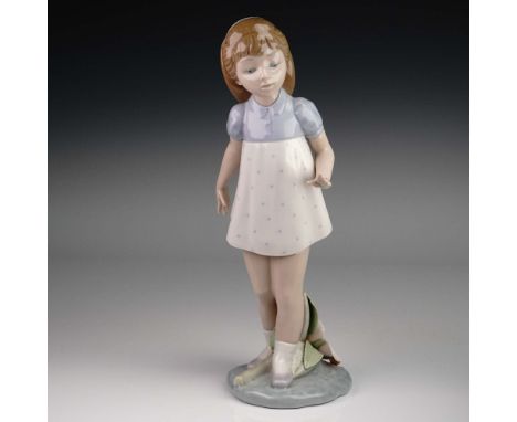 Lladro porcelain figurine model 01005040, titled Girl Walking, captures a graceful young girl in motion, with one hand raised