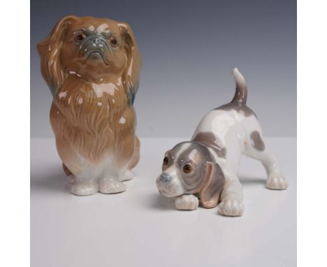 A delightful pair of porcelain figurines including Pekinese Sitting 1004641 and Playful Puppy 1009135. The first depicts a se