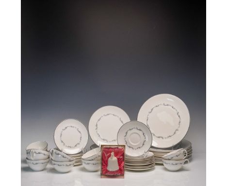 This 51-piece Royal Doulton bone china dinnerware set features the elegant Coronet pattern (H.4947), distinguished by its scr