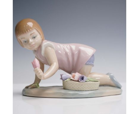 This delicate Lladro porcelain figurine, sculpted by Francisco Catala and issued in 1980, depicts a young girl kneeling as sh