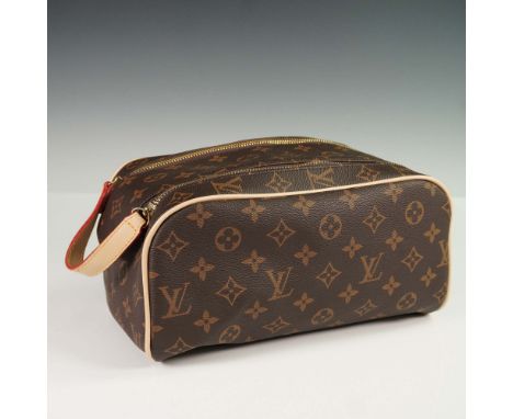 Crafted from the iconic Louis Vuitton monogram coated canvas with natural cowhide leather trim, this Trousse Toilette bag fea