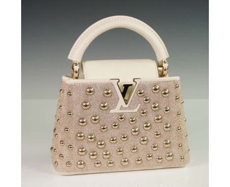 Louis Vuitton Capucines Mini handbag, crafted in France, featuring an elegant exterior of champagne-toned satin with intricat