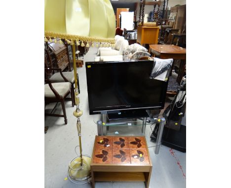 A Sharp flatscreen TV and glass stand together with an onyx effect standard lamp and shade and tile topped table