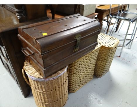 A vintage tin travel trunk and three modern laundry baskets
