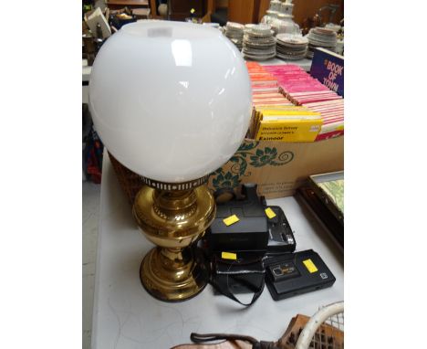 A brass based oil lamp, vintage cameras