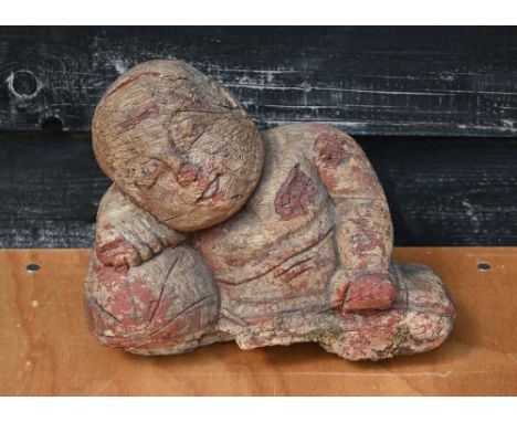 An antique heavily weathered Asiatic carved hardwood reclining buddha, light remnants of polychrome decoration 