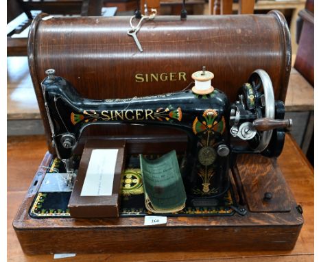 An antique Singer Sewing maching, decorated with Egyptian style decoration, no F9638968, to/w a box of accessories and a 1920