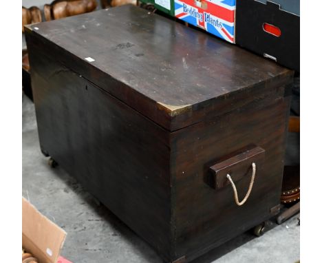 An antique brass bound teak trunk with rope carrying handles, on castors 102 x 54 x 70 cm high 