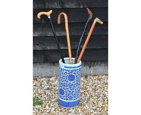 A Chinese blue and white ceramic cylindrical stick-stand with floral and foliate decoration, 46 cm high c/w four various walk