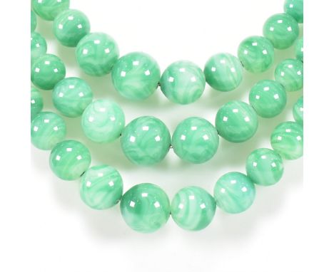 A 1930s French Peking glass triple strand necklace. The necklace having a simulated carved jade clasp. Stamped Made in France