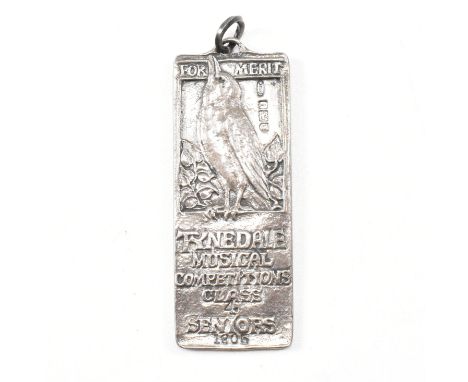 An Arts and Crafts hallmarked silver Ramsden and Carr pendant medal. The pendant presented for Merit Tyndale Musical Competit