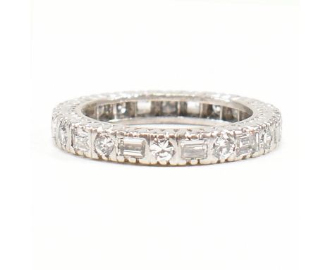 A French 18ct white gold and diamond eternity ring. The ring set with claw mounted baguette and round brilliant cut diamonds.