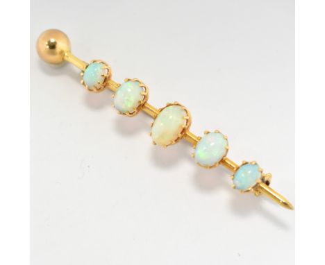 A early 20th century 15ct gold and opal bar brooch pin. The brooch set with five graduating oval cut opal cabochons to a bar 