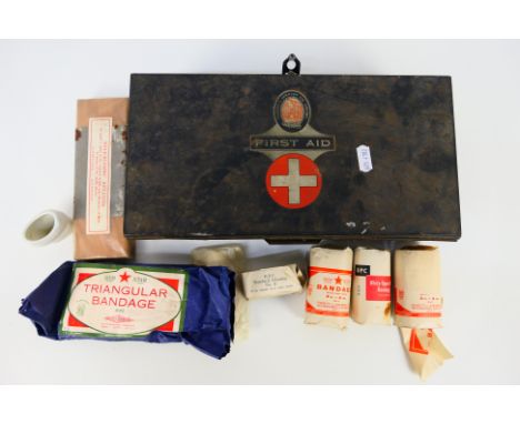 A vintage first aid tin with various contents to include bandages, telescopic splints, ceramic eye bath. [W]